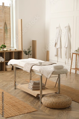 Stylish massage room interior with spa table in salon