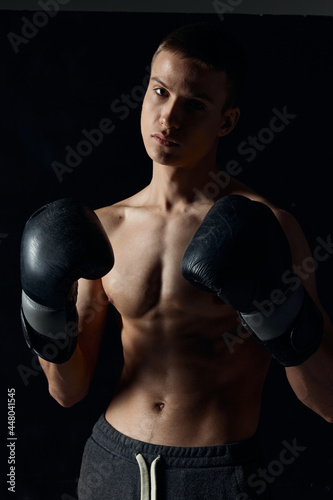athlete boxing gloves on a black background nude torso boxing workout © SHOTPRIME STUDIO