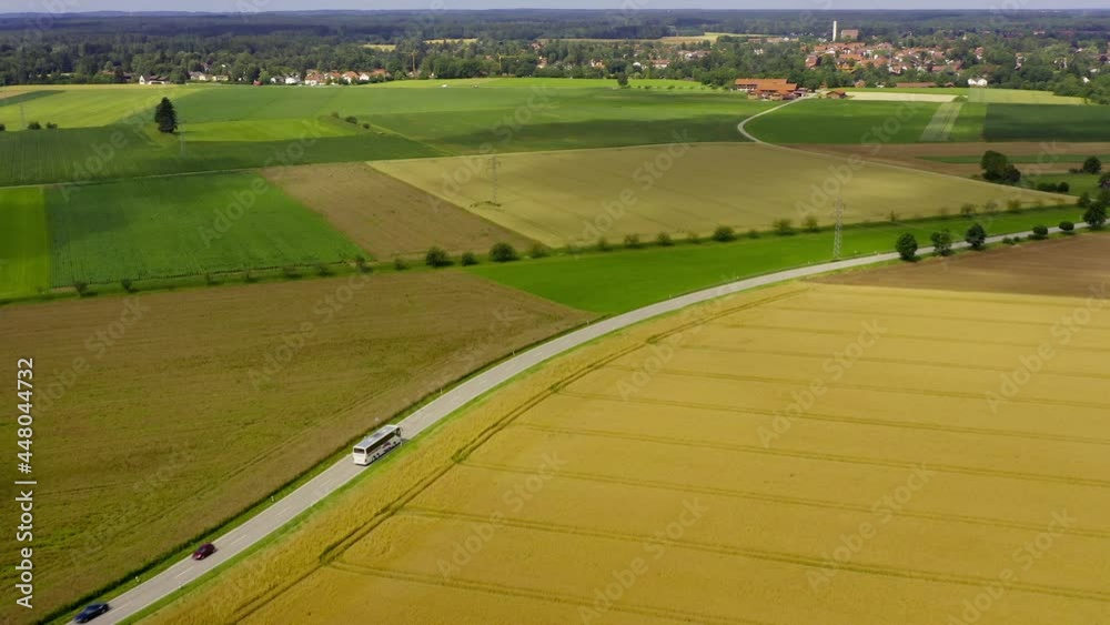 Flying over rural blooming fields following a driving bus passing by the peaceful summer landscape Flying over rural blooming fields following a driving bus passing by the peaceful summer landscape