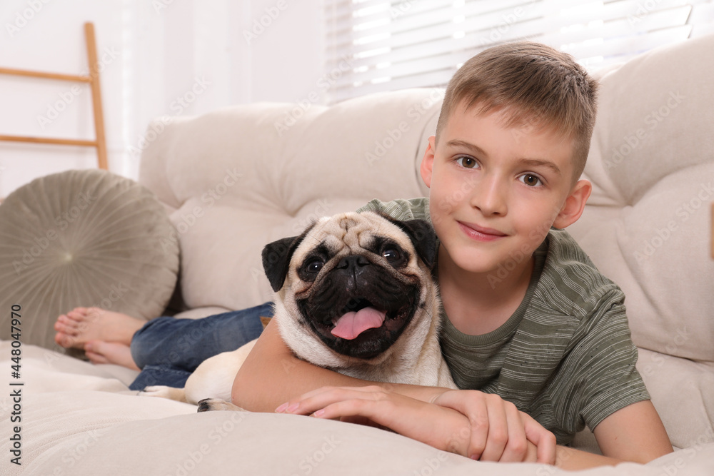 Boy with his cute pug on sofa at home Boy with his cute pug on sofa at home