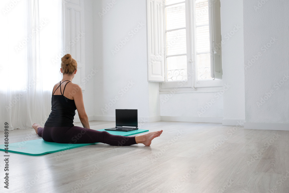 woman practicing yoga on yoga mat whit laptop woman practicing yoga on yoga mat whit laptop