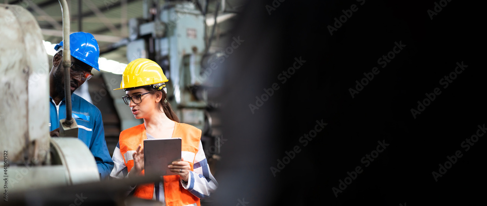 Quality control inspector checking workers at factory. Engineering Worker team working in Heavy Industry Manufacturing Facility.