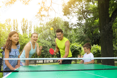 Happy family playing ping pong in park © New Africa