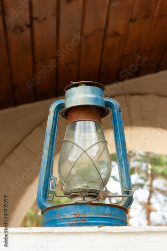 A vintage kerosene lamp stands on the window. © Rara