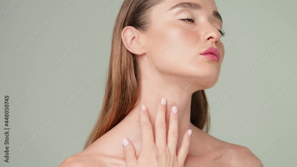 Beautiful Young Woman with Clean Fresh Skin standing over light grey background Beautiful Young Woman with Clean Fresh Skin standing over light grey background