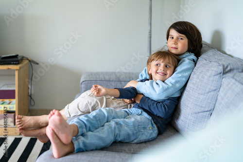 Foto Two brothers are sitting on a sofa at home