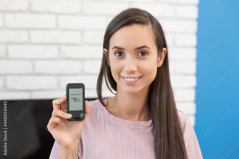 Woman using glucometer at home Woman using glucometer at home