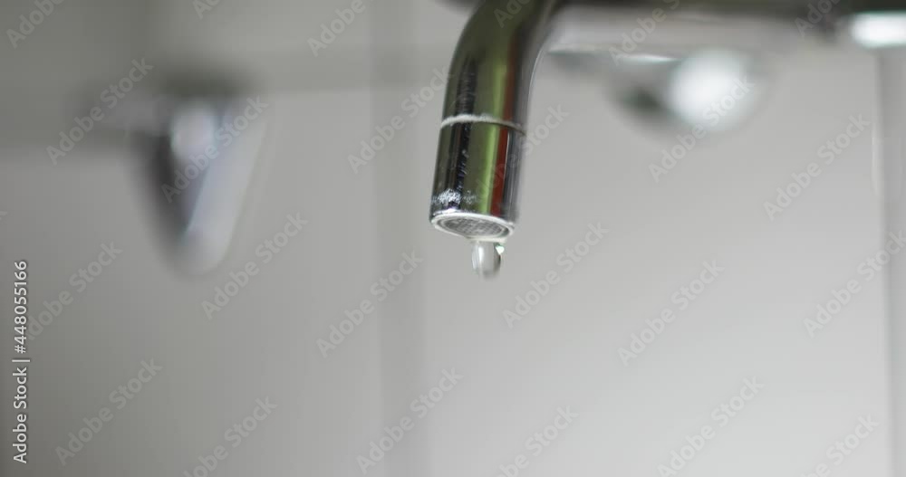 Metal faucet nozzle dripping water droplets close up macro shot. Real time, no people, shallow depth of field Metal faucet nozzle dripping water droplets close up macro shot. Real time, no people, shallow depth of field