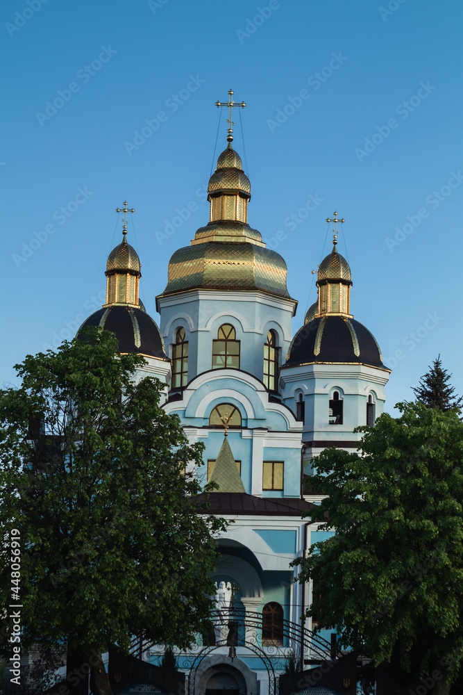 Ukrainian Orthodox Church with golden domes against the background of a blue evening sky. Ukraine.