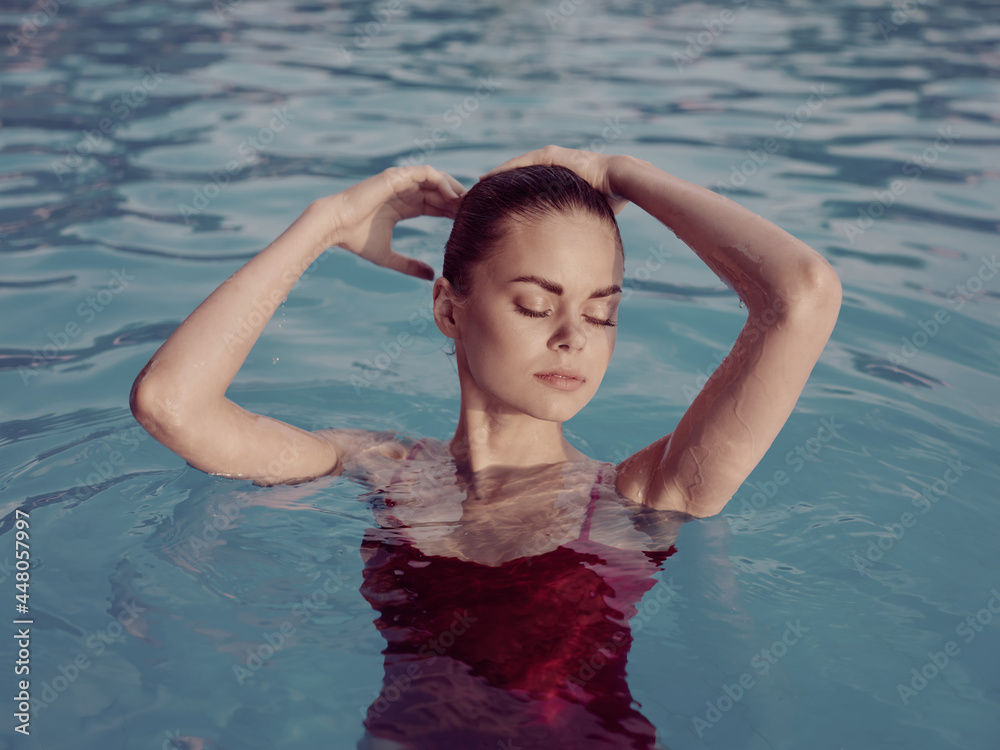 woman in swimsuit holds hands on head closed eyes pools luxury