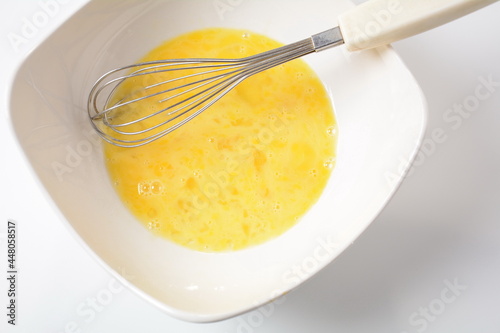 Proсess of cooking Omelette . Beaten egg yolks in a bowl with whisk