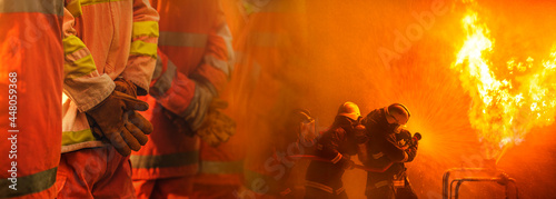 Web banner concept firefighter team work, Team fireman stand in row with professional team firefighter working spraying high pressure water to fire.