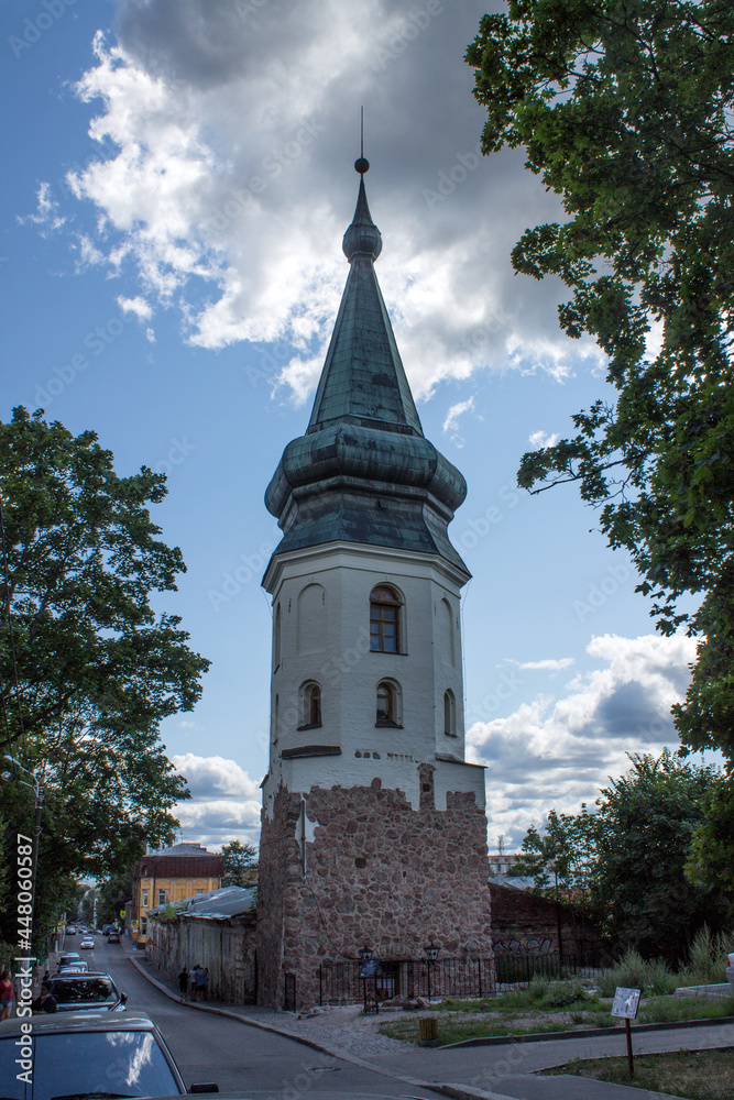 Fototapeta premium VYBORG, Leningrad REGION, RUSSIA-July, 19, 2021: the facade of the old medieval Town Hall tower and the cloudy sky on a sum