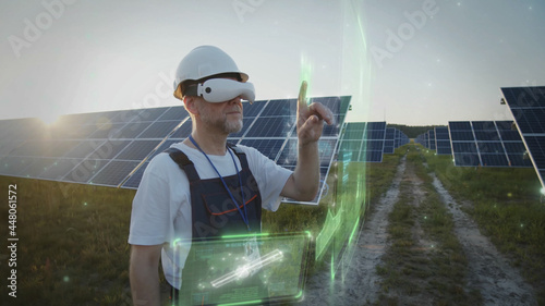 Adult man engineer using VR glasses checking solar battery panels tapping online. 3D graphic system. Sunset sky. Futuristic technology innovation. Eco business trend. Virtual reality inspiration. 5G