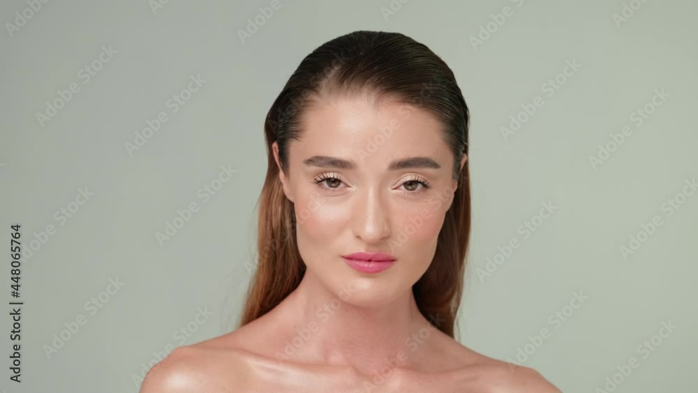 Beautiful Young Woman with Clean Fresh Skin standing over light grey background Beautiful Young Woman with Clean Fresh Skin standing over light grey background