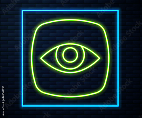 Glowing neon line Security camera icon isolated on brick wall background. Vector