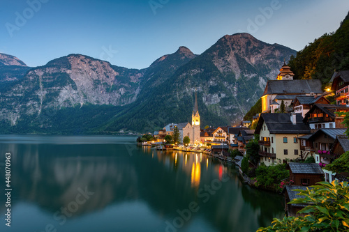 Hallstatt, Austria ; July 31, 2021 - A scenic picture postcard view of the famous village of Hallstatt reflecting in Hallstattersee lake in the Austrian Alps.