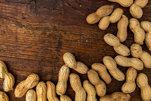 A lot of penuts on wooden background