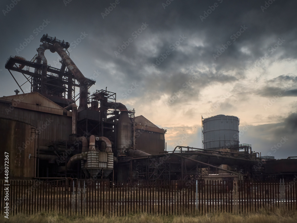 Low-key, atmospheric view of the abandoned Redcar Steelworks Blast Furnace, now closed and scheduled for demolition, ahead of a dramatic sky.