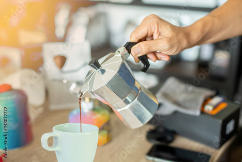 Pour the coffee from the kettle into the glass.