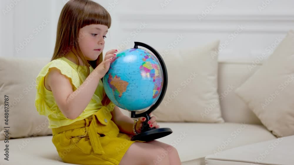 child looking at the globe sitting on the couch child looking at the globe sitting on the couch