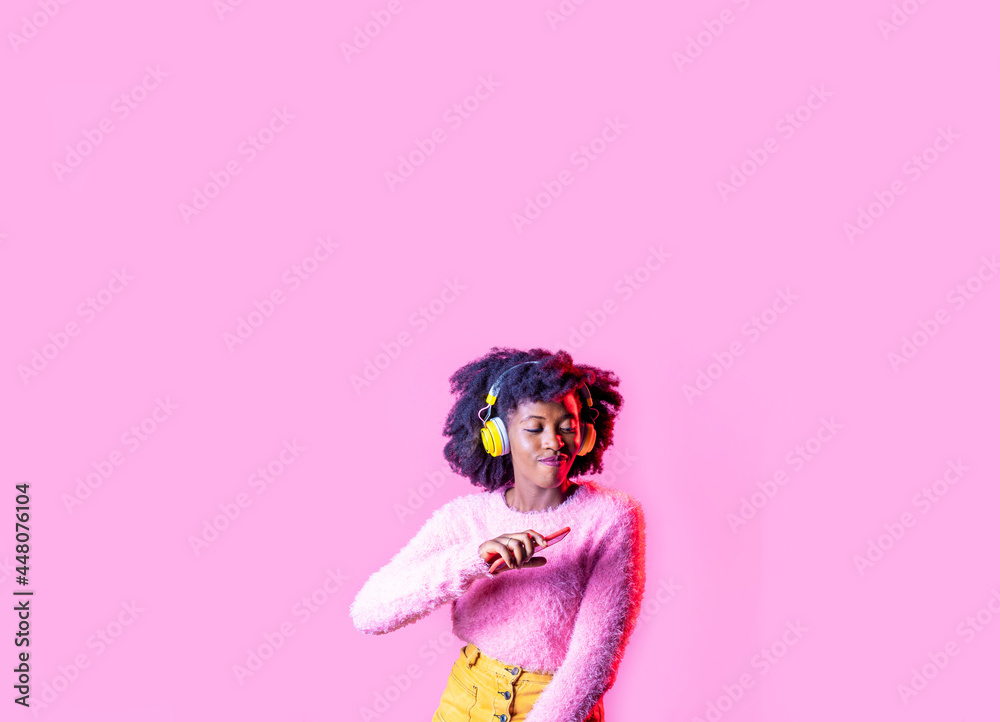Young black woman isolated copy space advertising banner dancing listening music wireless headphones and smartphone Young black woman isolated copy space advertising banner dancing listening music wireless headphones and smartphone