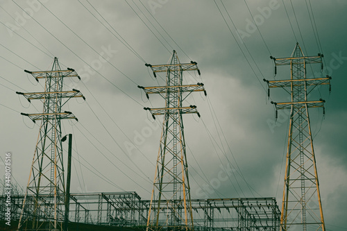 High tension power lines with bruised, storm clouds and dramatic sky