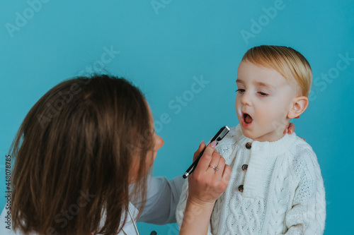 Woman Doctor looks at the boy's throat