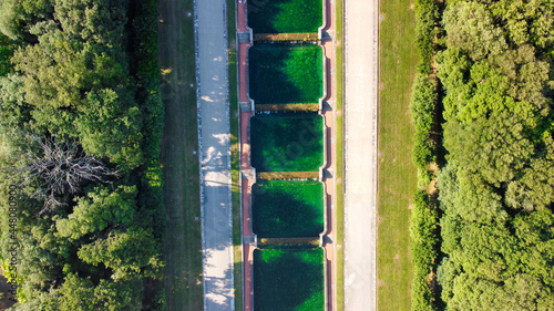 Reggia di Caserta, Italy. Aerial view of famous royal building gardens and pools from a drone in summer season.