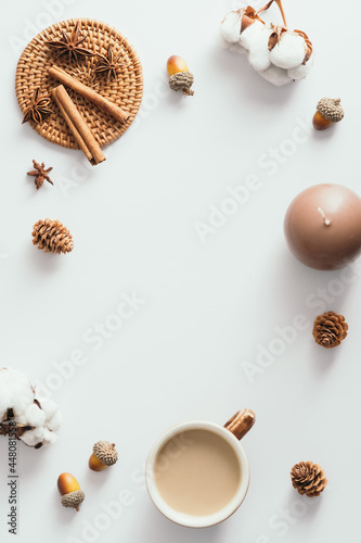 Autumn composition. Coffee cup, candles, cotton, cinnamon sticks on white background. Autumn, fall concept. Flat lay, top view, copy space