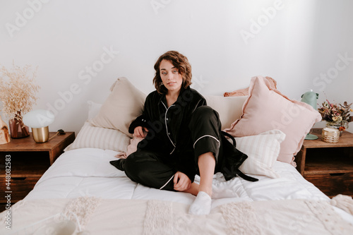 Delicate woman in pajama sitting in bed photo