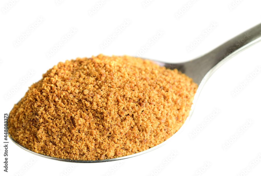 Coconut Sugar in a Spoon. Isolated on White. Dehydrated Sap of the Coconut Palm Tree. Coconut Sugar in a Spoon. Isolated on White. Dehydrated Sap of the Coconut Palm Tree.