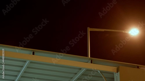 Street lamp over rooftop at night photo