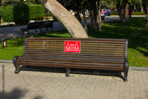 Baku. Azerbaijan. 05.29.2020 year. Bench on the boulevard with a warning to keep your distance. photo