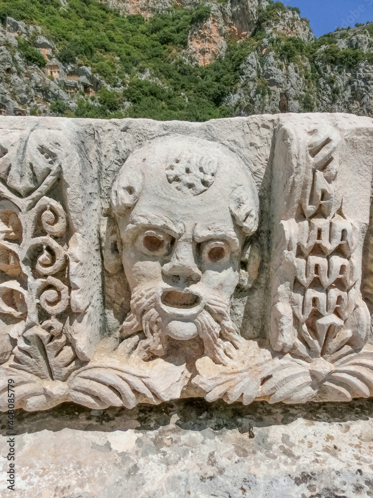 Obraz premium Masks and rock tombs in Myra, Turkey