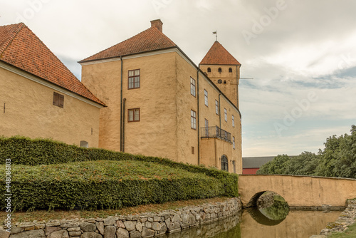 Tosterup castle with huge yellow buildings and a bridge over the moat photo