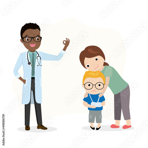 Mom hugs and soothes upset boy. Child with trauma at podiatrist appointment. African american doctor says everything is fine