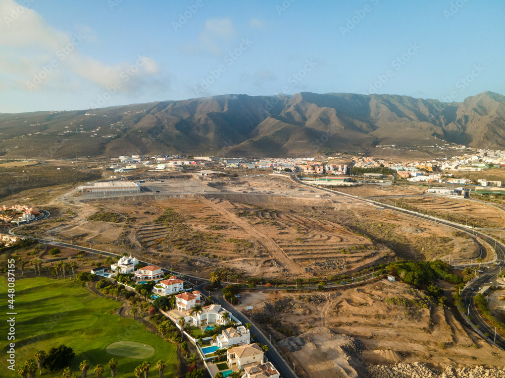 Naklejka premium Tenerife, a town on the Atlantic Ocean. Sunny coast and dry soil. Ocean, water, waves, blue ocean.