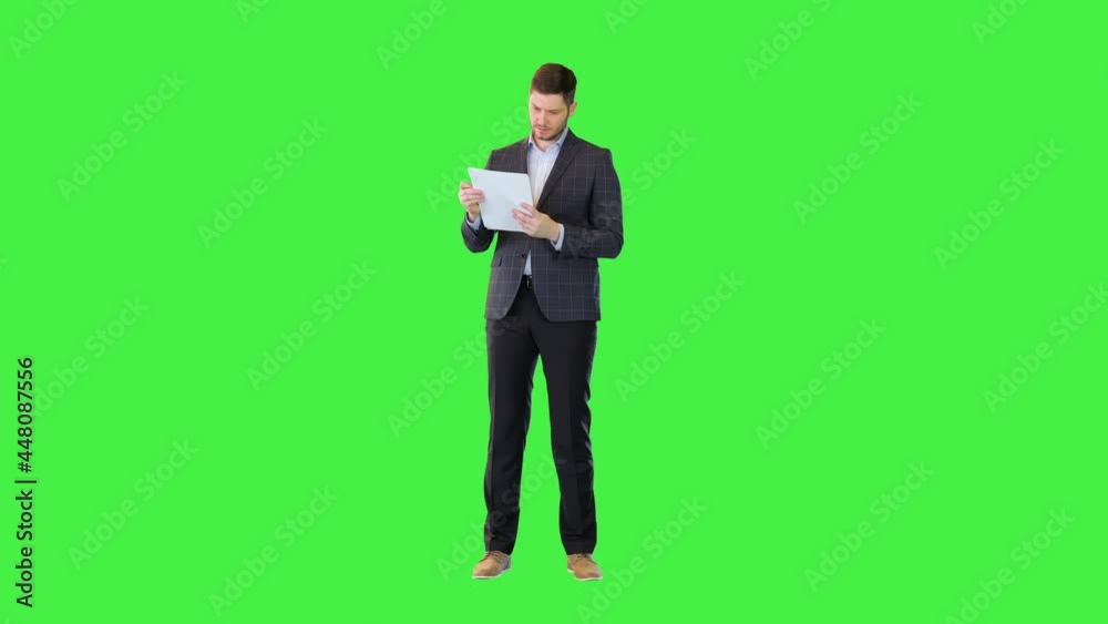 Concentrated thoughtful businessman in formal suit read business documents with worried pensive face on a Green Screen, Chroma Key. Concentrated thoughtful businessman in formal suit read business documents with worried pensive face on a Green Screen, Chroma Key.