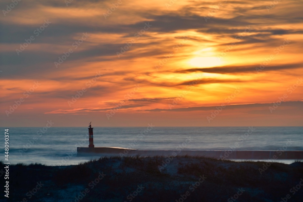 Sunset with lighthouse in the Atlantic Ocean