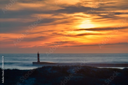 Sunset with lighthouse in the Atlantic Ocean