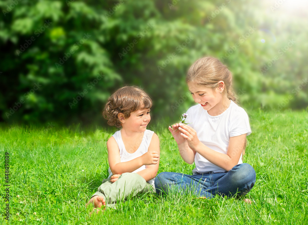 children sit on the grass outdoors and smile children sit on the grass outdoors and smile