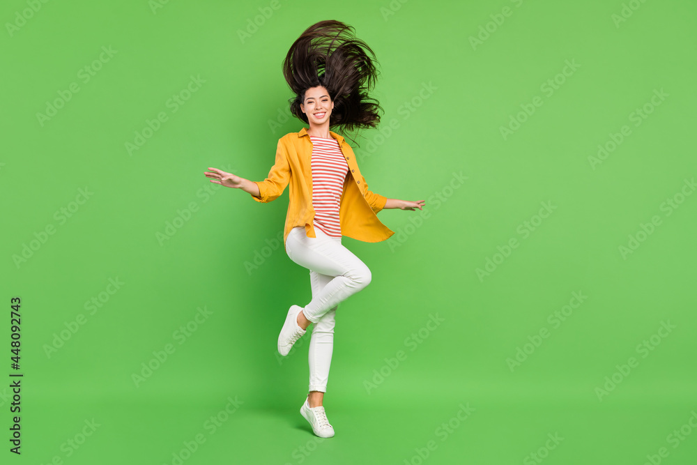 Photo of pretty adorable young woman dressed casual clothes dancing walking smiling isolated green color background
