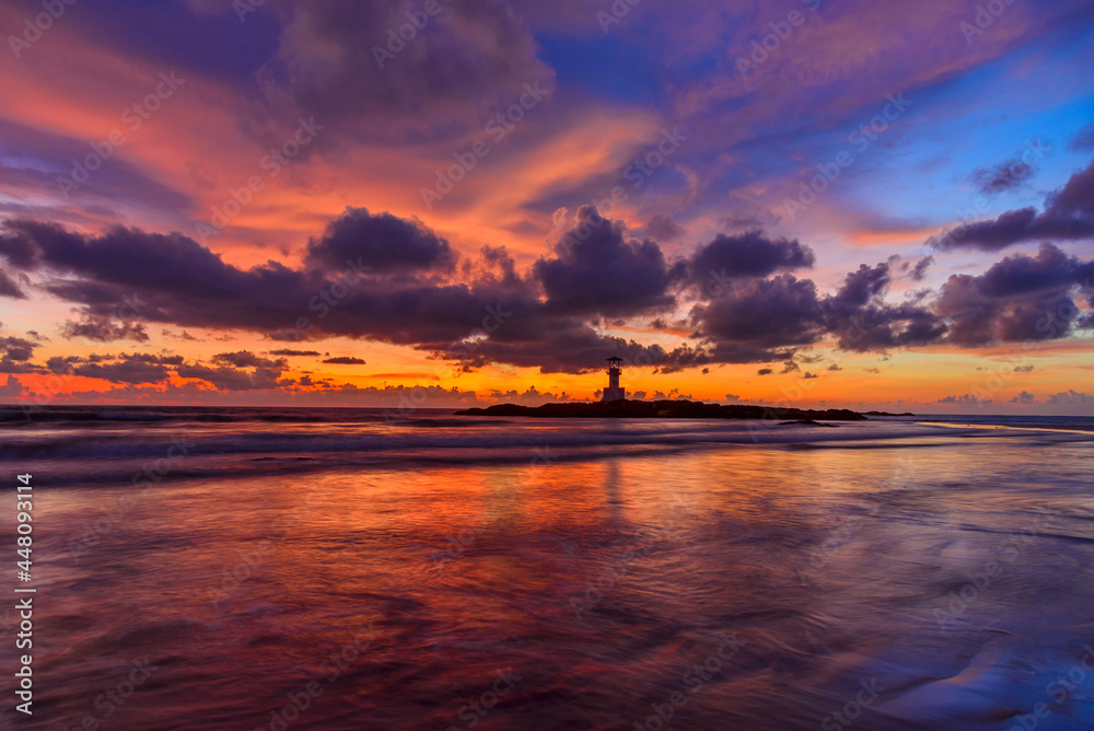 The scenery of the silhouette of Khao Lak Light Beacon in sunset time with the dramatic twilight sky at Nang Thong Beach, Phang Nga, Thailand.