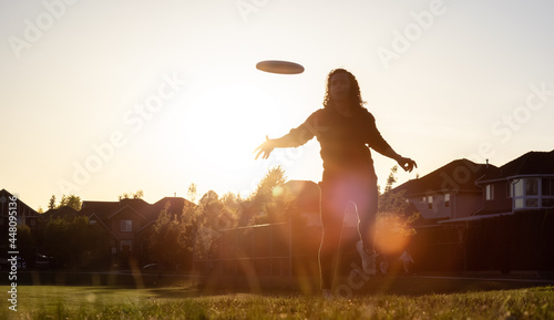 Obraz na plátně White Caucasian Adult Woman Playing Ultimate Frisbee in the Green Field at neighborhood city park