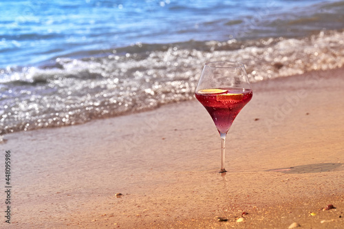 Wine glass with a cocktail by the sea.