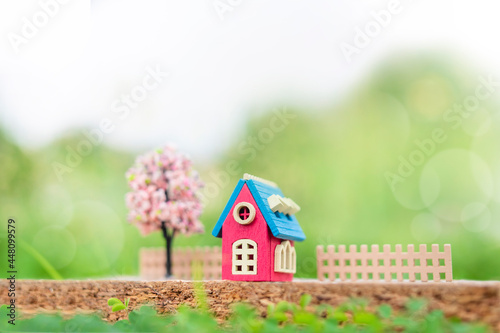 Wood home and toy model on green nature.