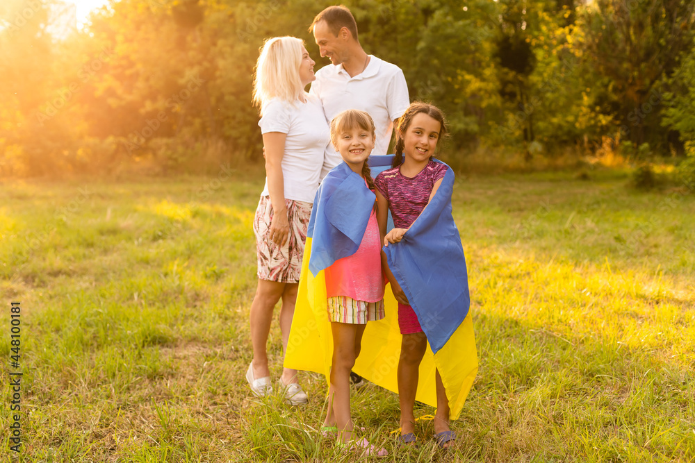Fototapeta premium Flag Ukraine in hands of little girl in field. Child carries fluttering blue and yellow flag of Ukraine against background field.