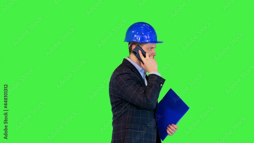 Construction engineer in hardhat or inspector supervisor executive answer mobile phone call walking on a Green Screen, Chroma Key. Construction engineer in hardhat or inspector supervisor executive answer mobile phone call walking on a Green Screen, Chroma Key.