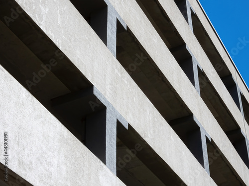 Facade of a multi-level car parking on a background of blue sky